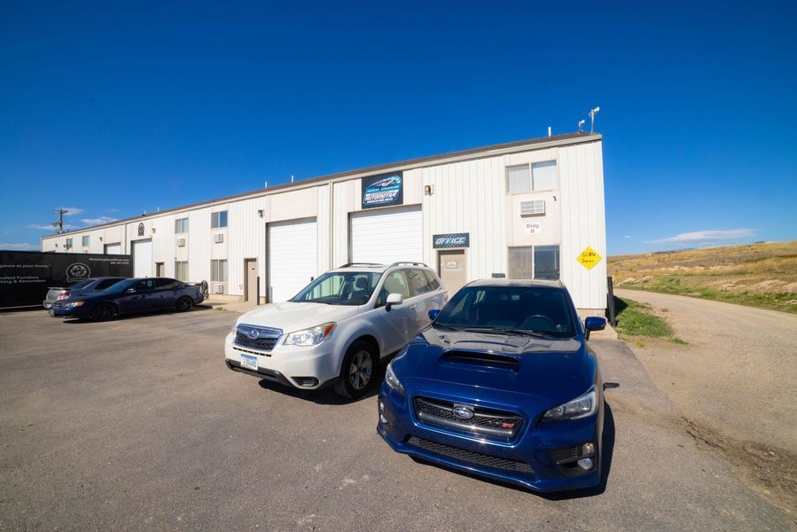 Two cars are parked in front of a building.