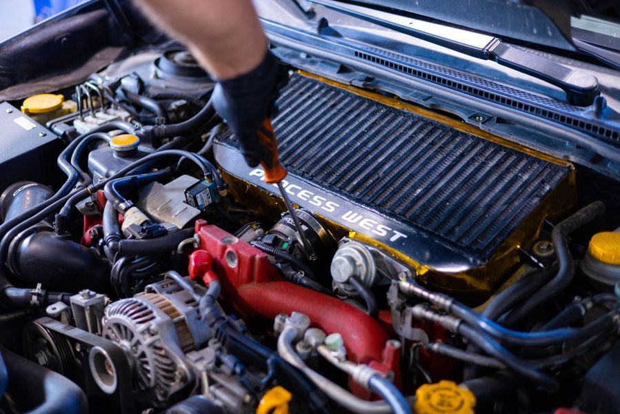 A person is working on the engine of a car.