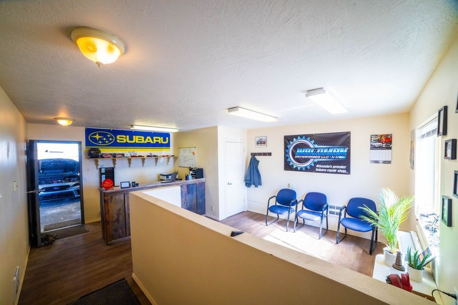 A waiting room with a subaru sign on the wall.