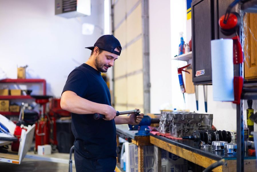 A man is working on a piece of metal in a garage.