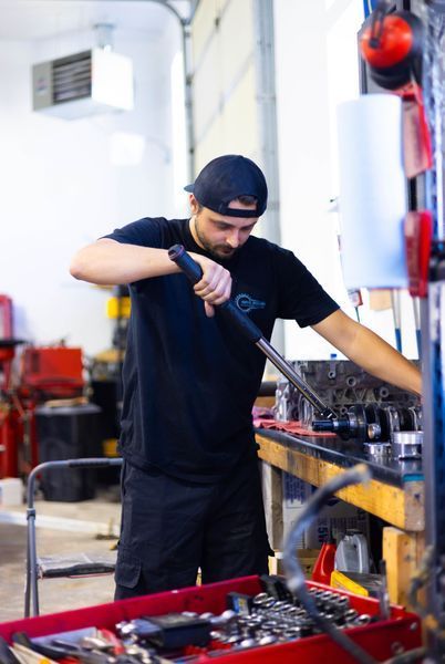A man is working on a piece of equipment in a garage.