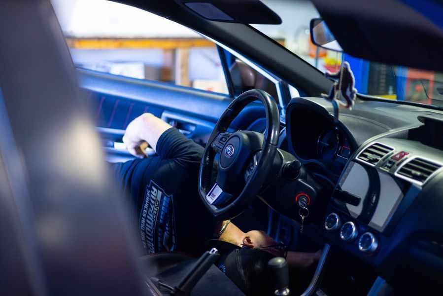 A person is sitting in the driver 's seat of a car.