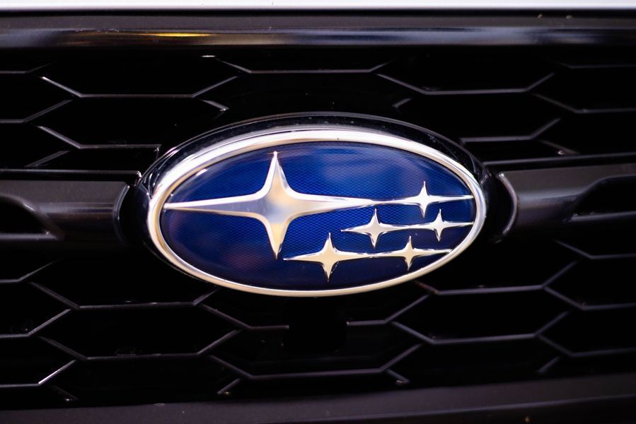 A close up of a subaru logo on the front of a car