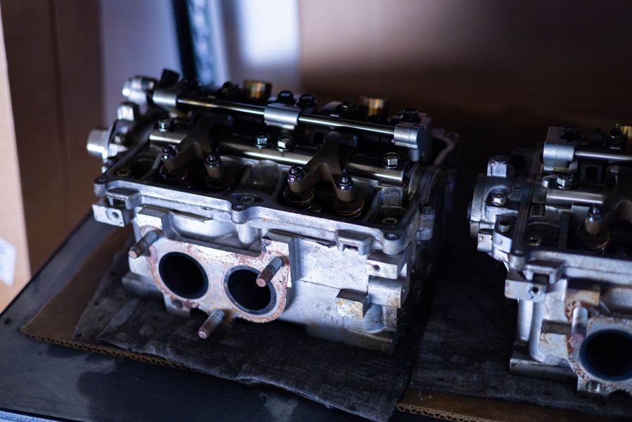 Two engine heads are sitting on top of each other on a table.