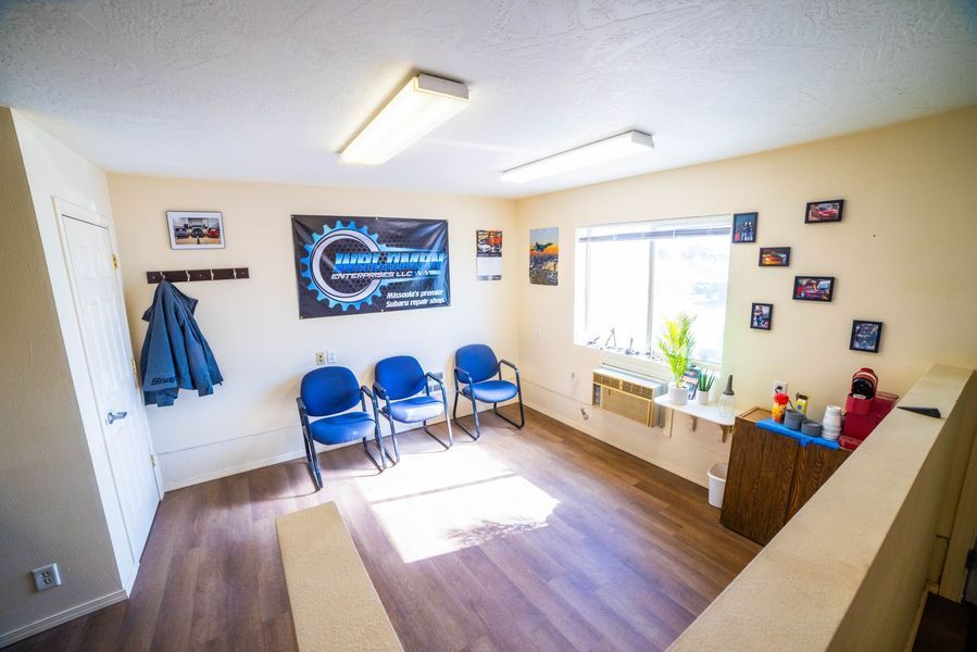 A waiting room with chairs and a sign on the wall.