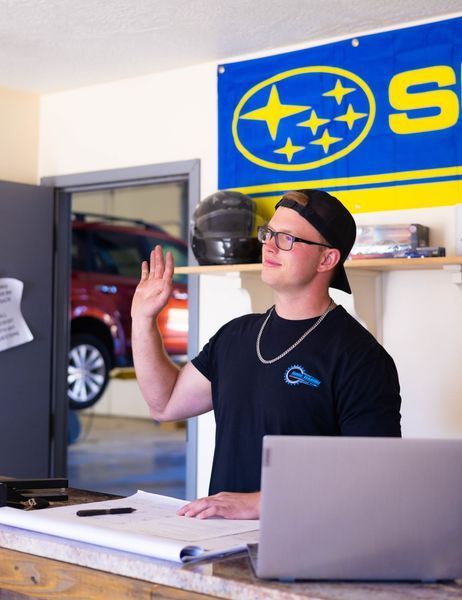 A man standing in front of a subaru sign