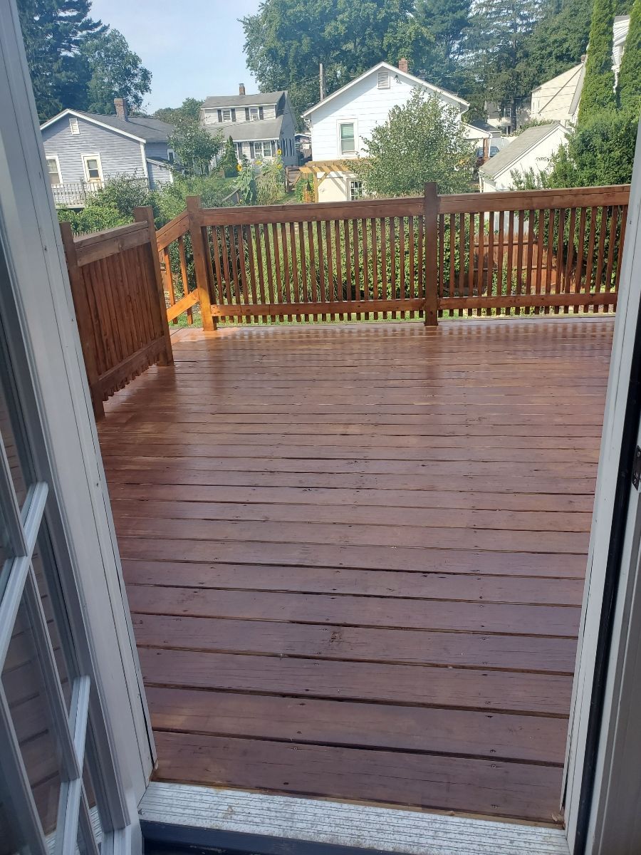 A Wooden Deck with a fence and houses in the background – Malden, MA – EG Remodeling LLC