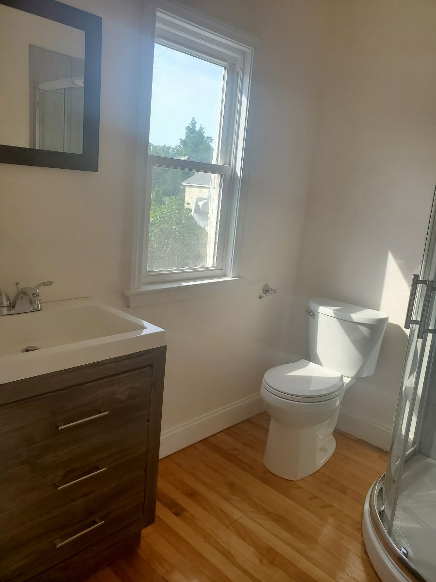 A Bathroom with a toilet a sink and a window – Malden, MA – EG Remodeling LLC