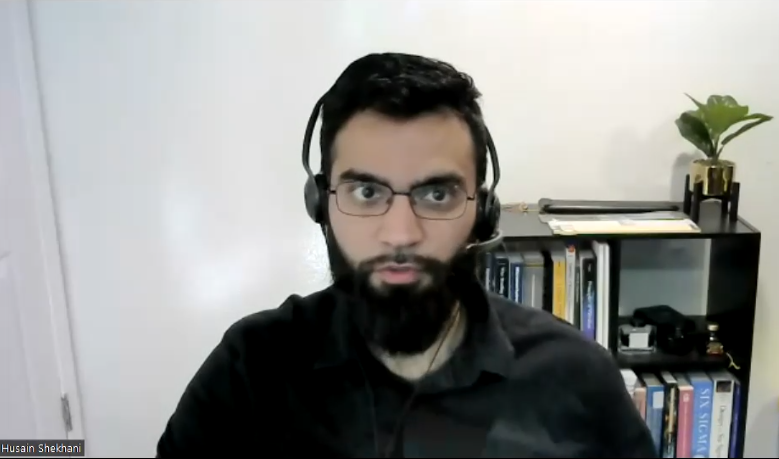 A man with a beard wearing headphones and glasses