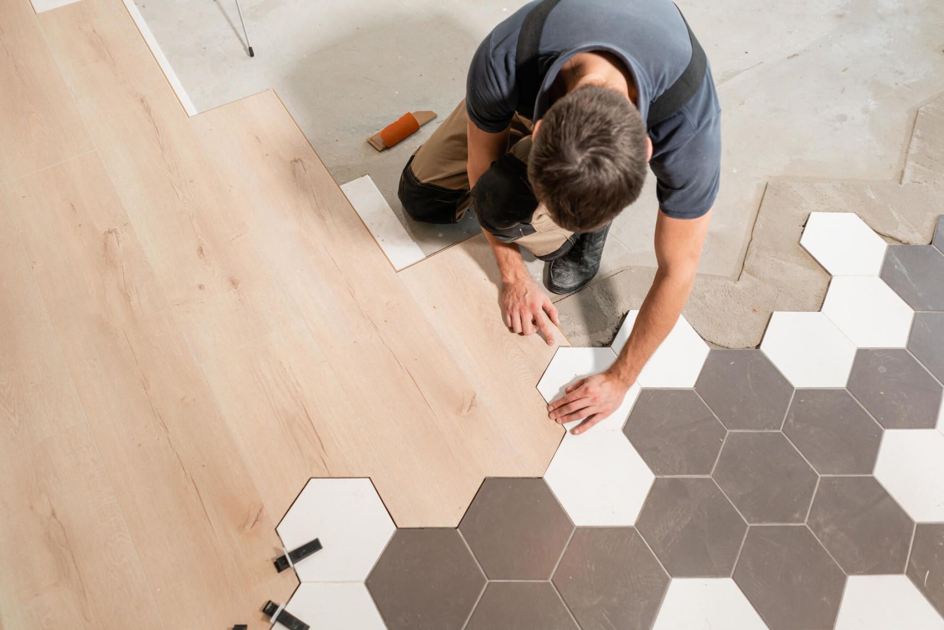 Male Worker Installing New Wooden Laminate Flooring — North Myrtle Beach, SC — Williams Carpet Center