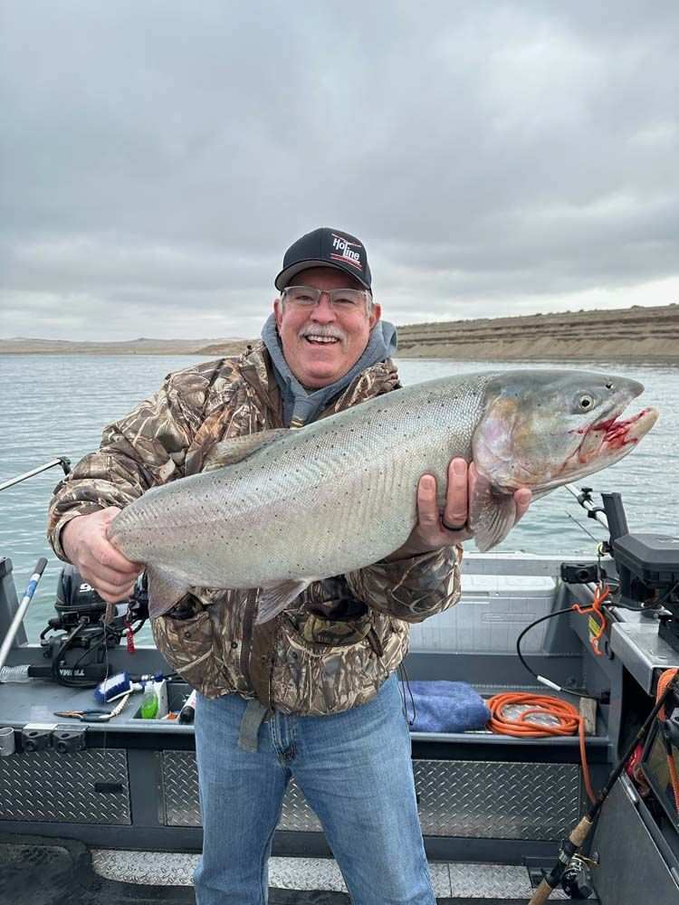 A man is holding a large fish on a boat.