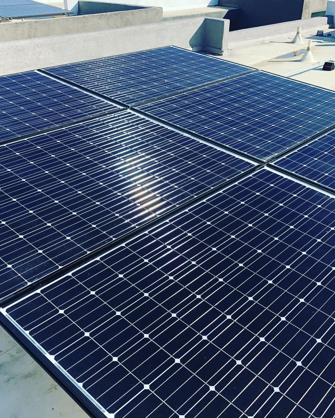 A row of solar panels sitting on top of a roof