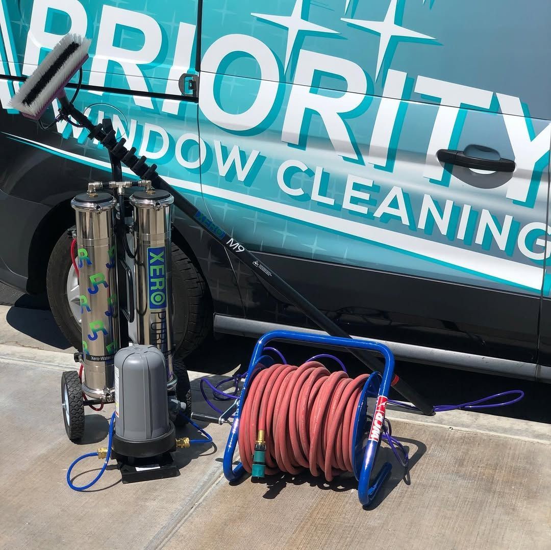 A priority window cleaning van is parked on the side of the road