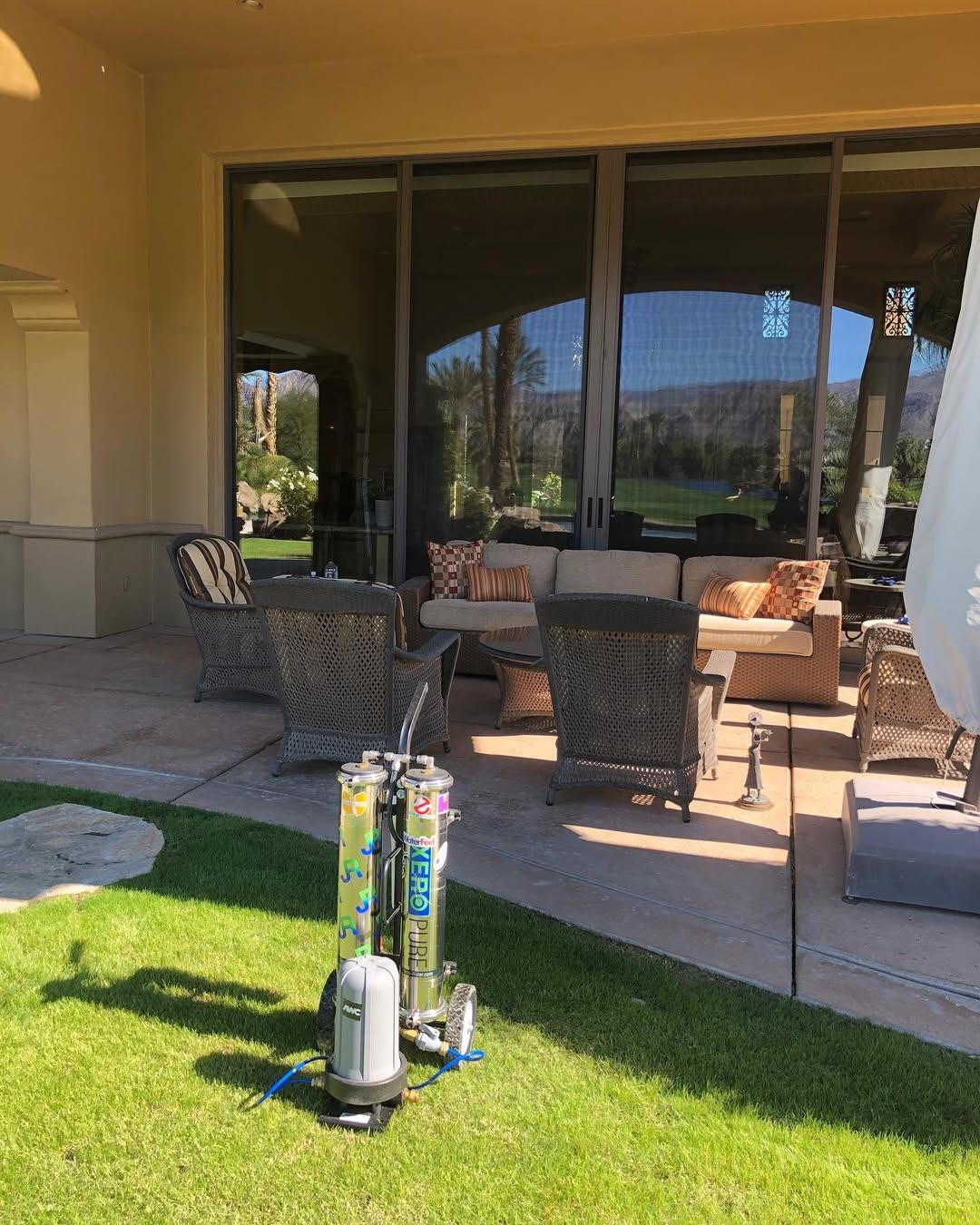 A patio with a lot of furniture and a large window.