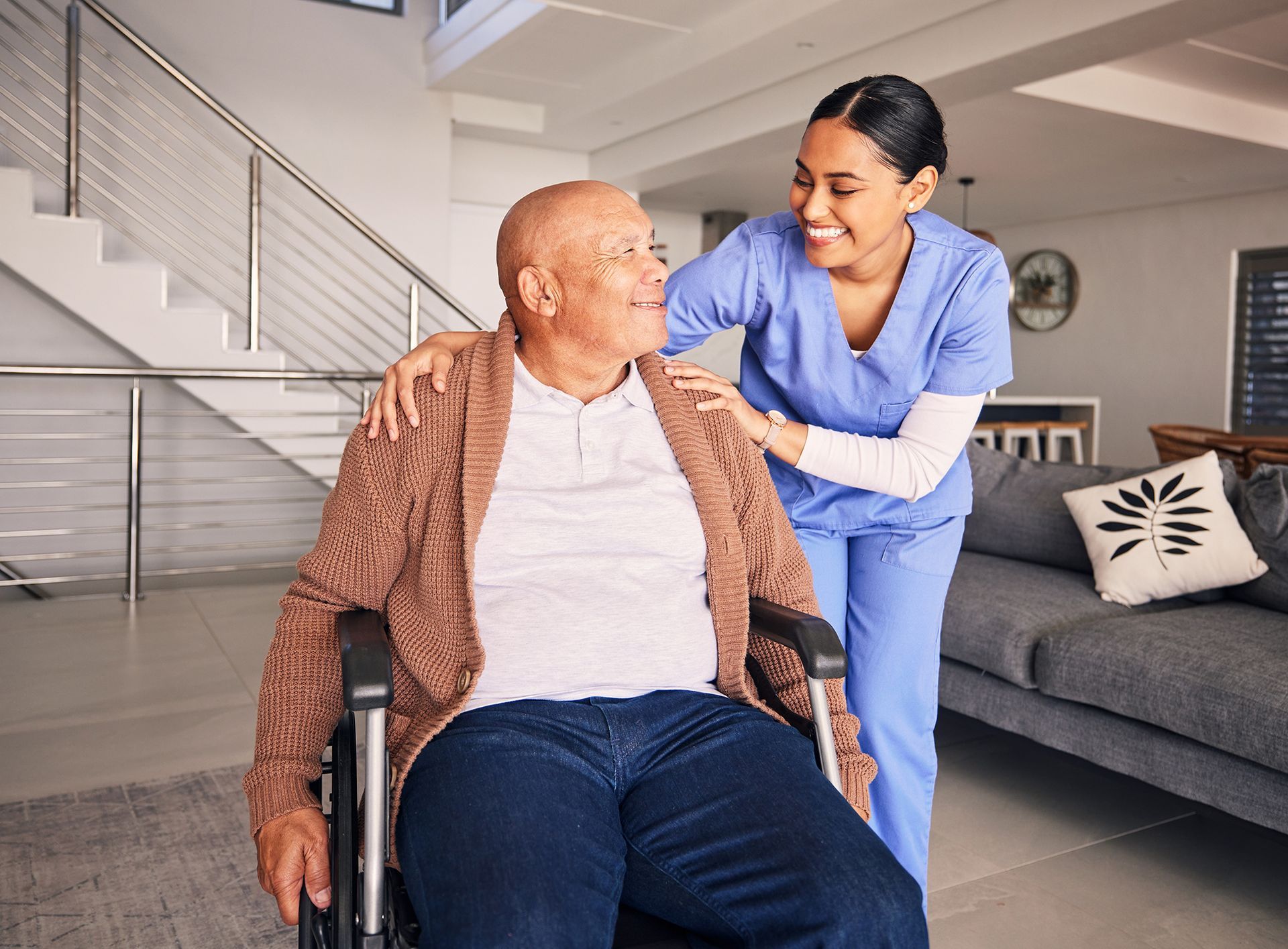 A nurse is helping an elderly man in a wheelchair.