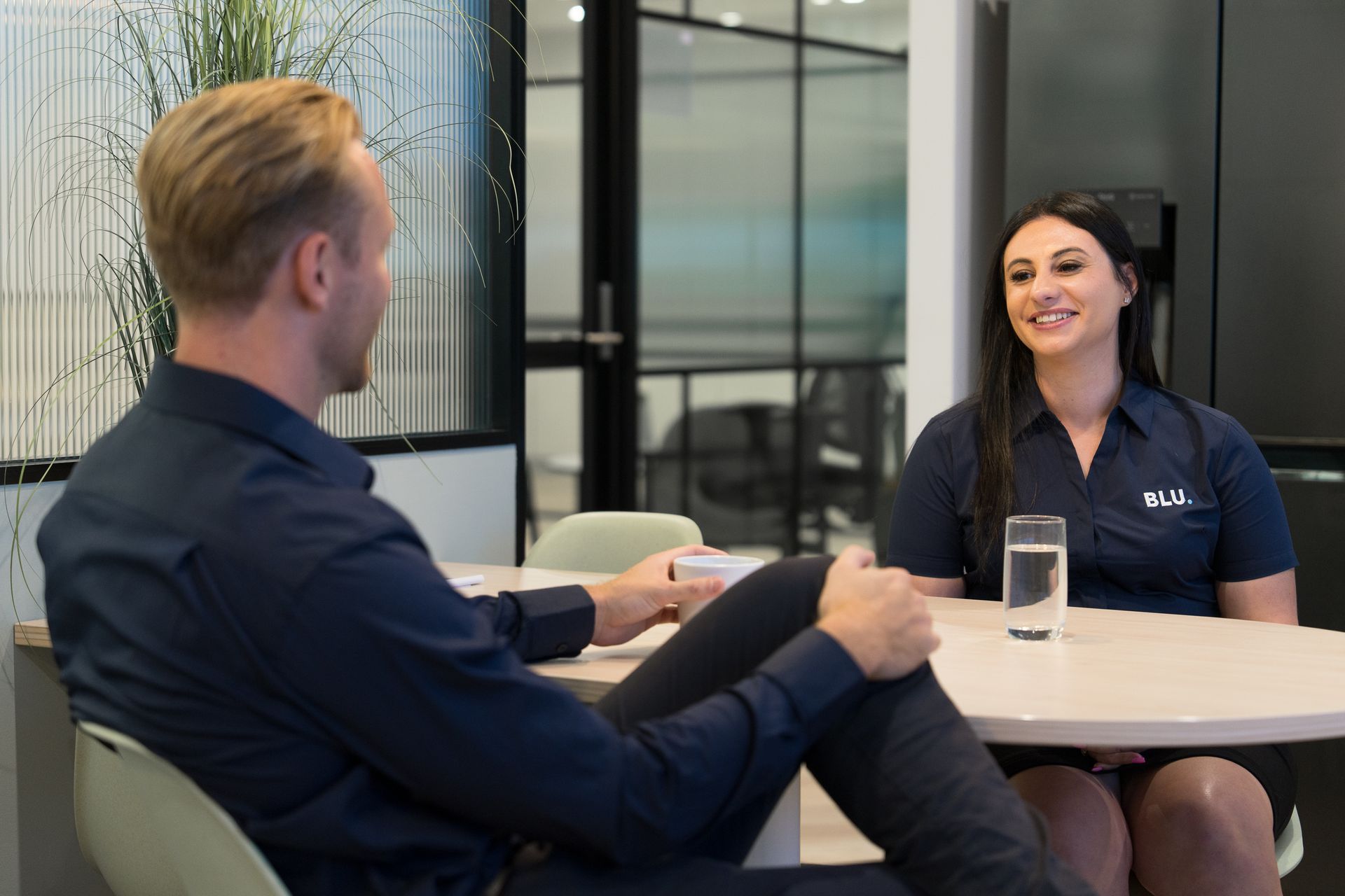 A man and a woman are sitting at a table having a conversation.