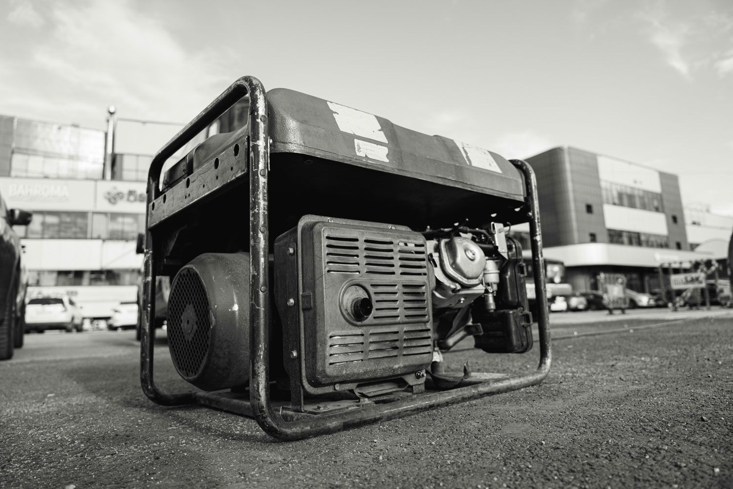 A black and white photo of a generator in a parking lot.