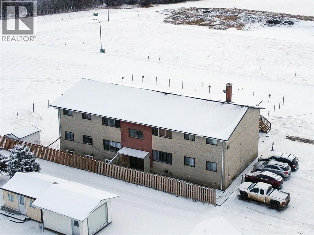 A large, yellow, mesh-constructed sculpture of a bee mounted on a white pole against a blue, cloudy sky.