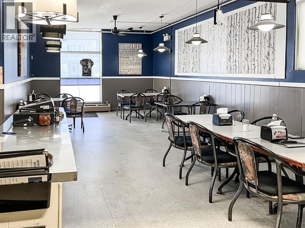 The Girouxville Museum, a light-colored building with a blue-striped awning, stands under a partly cloudy sky.