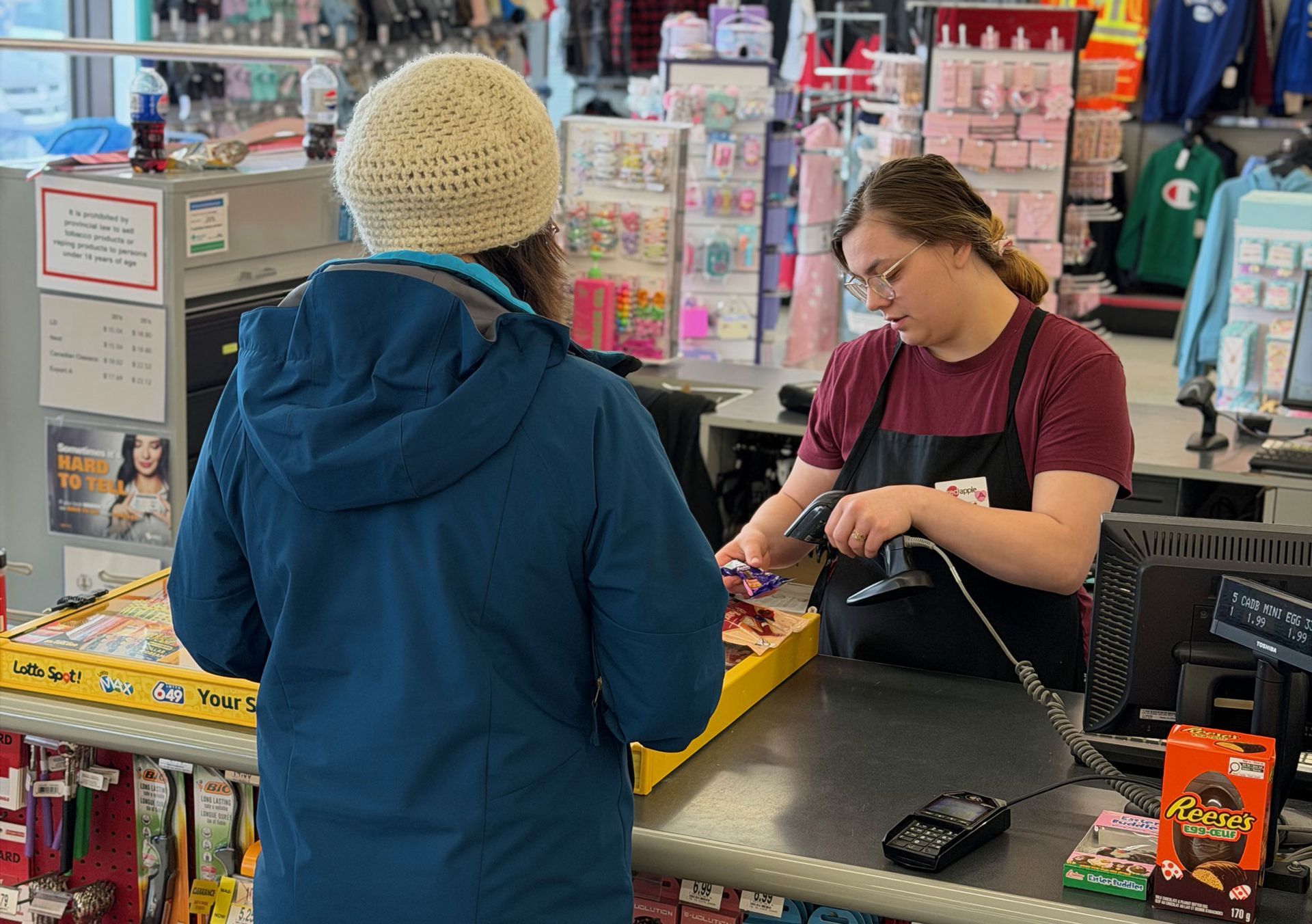 A giant, yellow, metal-framed sculpture of a bee mounted on a white pole against a blue, cloudy sky.