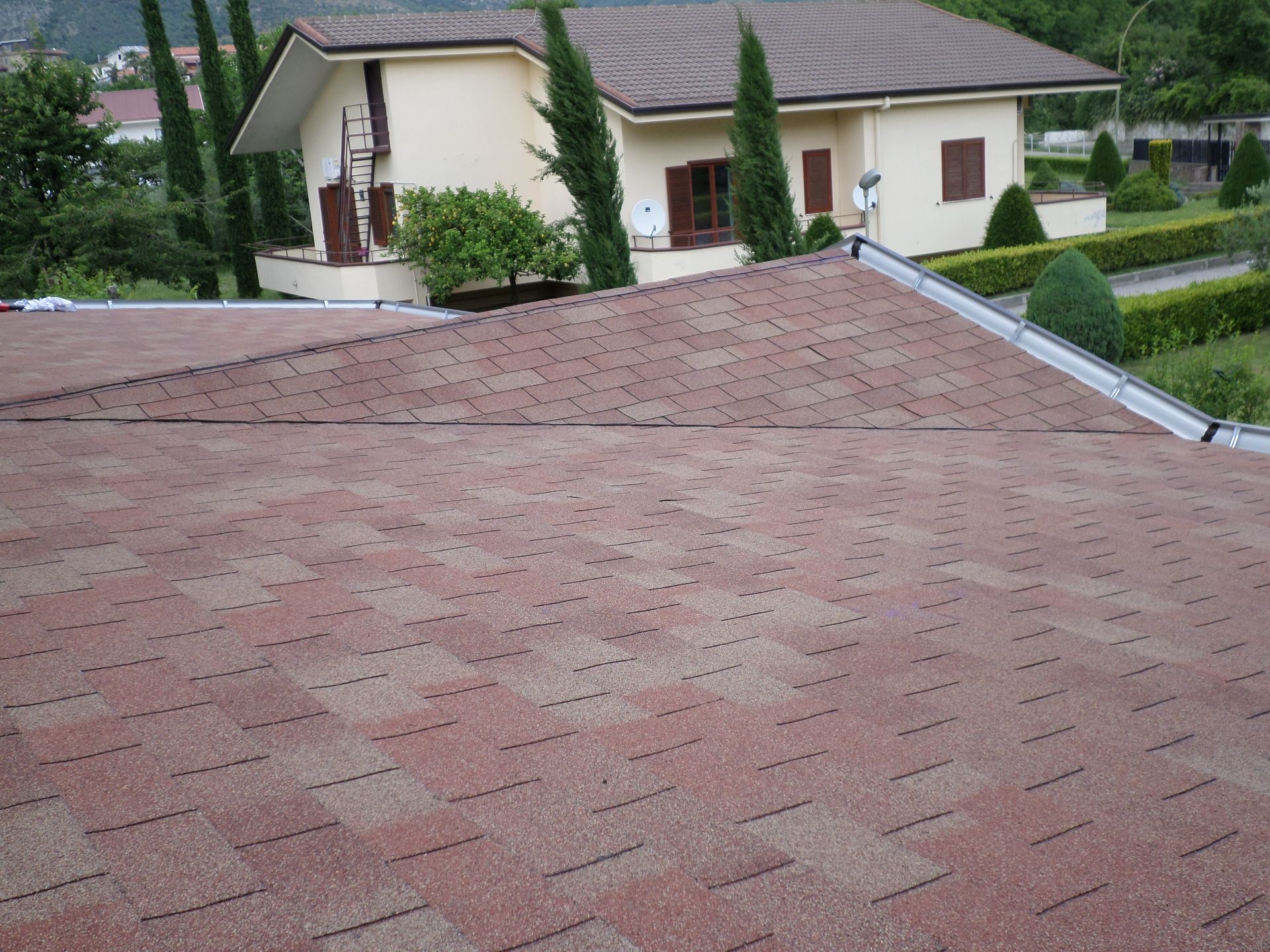 Una casa con il tetto rosso e gli alberi sullo sfondo