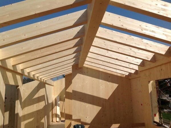 Una stanza con un soffitto fatto di travi di legno