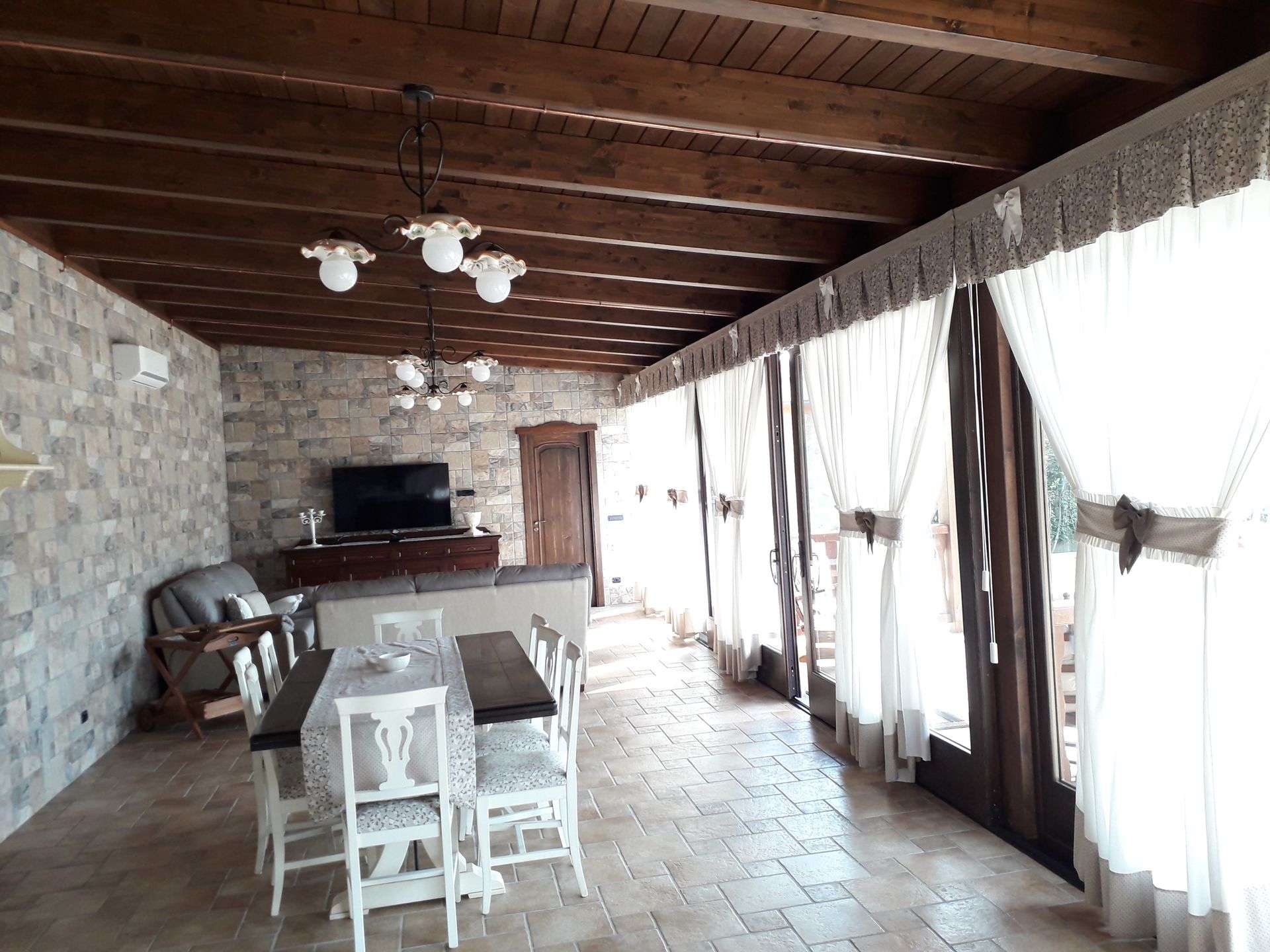 Un soggiorno con tavolo da pranzo, sedie e televisione.