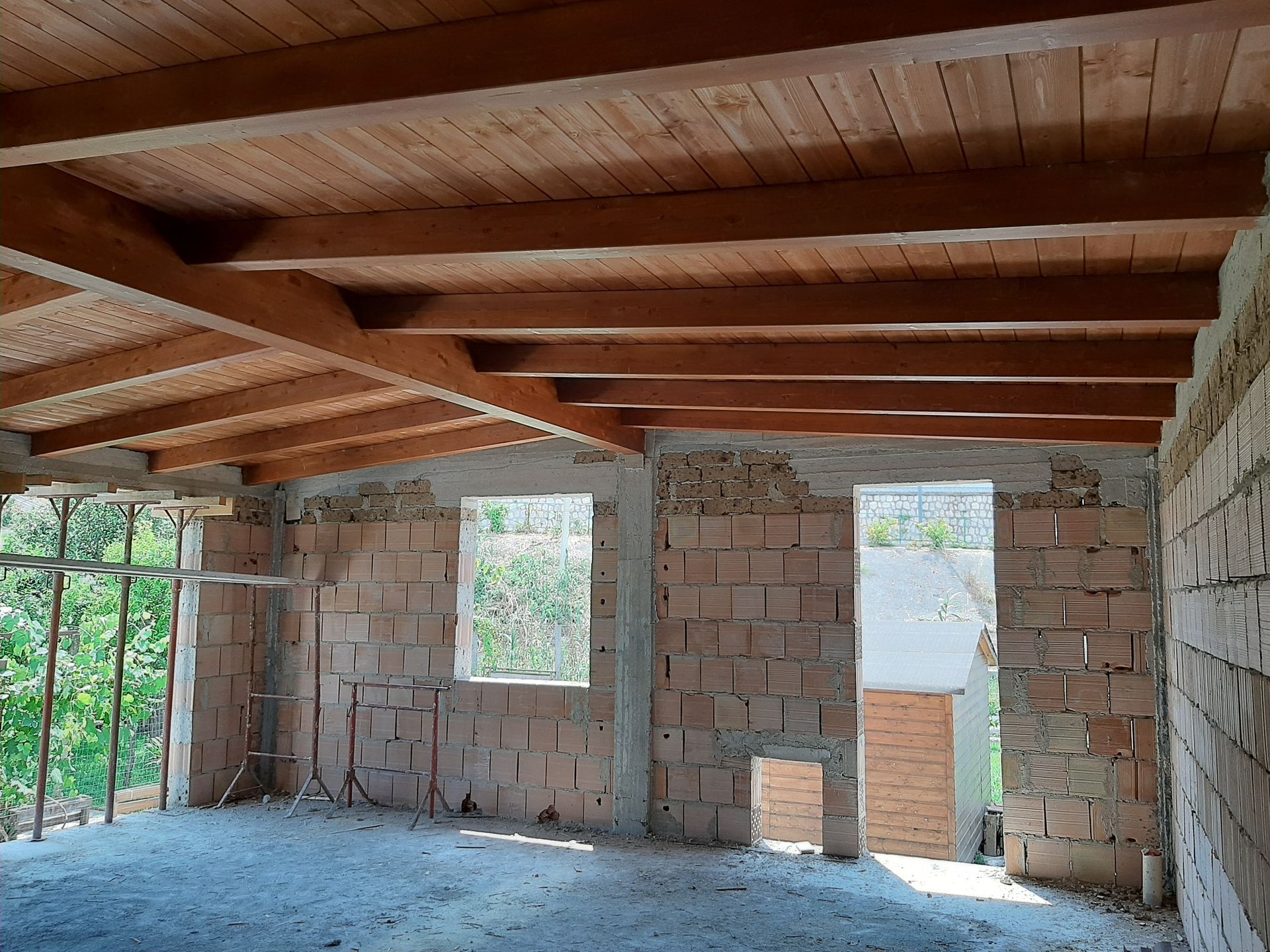 Una stanza con soffitto in legno e pareti in mattoni