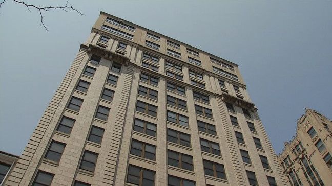 looking up at a tall building with a lot of windows on a sunny day .