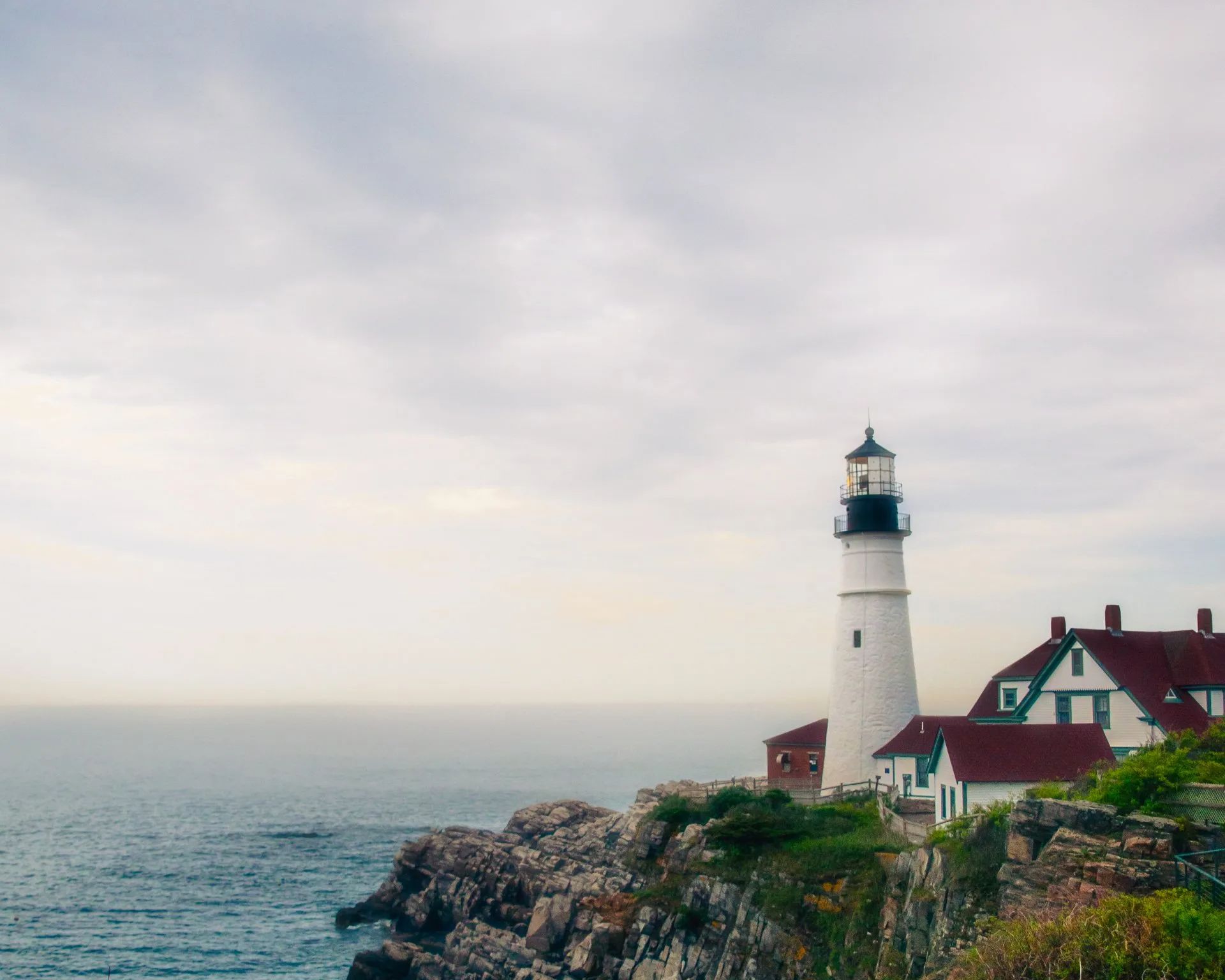 a lighthouse sits on a cliff overlooking the ocean