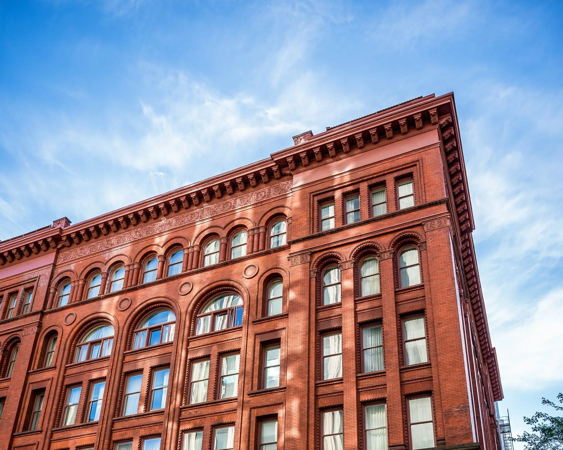 a black car is parked in front of a large brick building