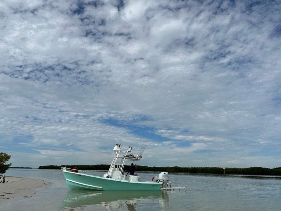 A boat is sitting on the shore of a body of water.