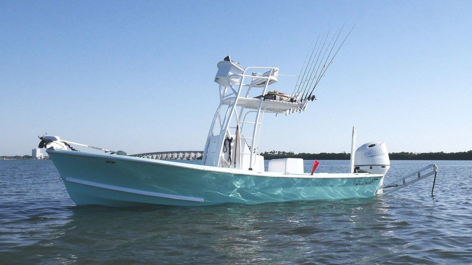 A white boat is floating on top of a body of water.