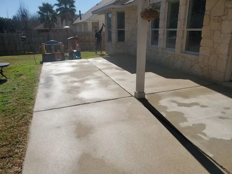 A concrete driveway in the backyard of a house