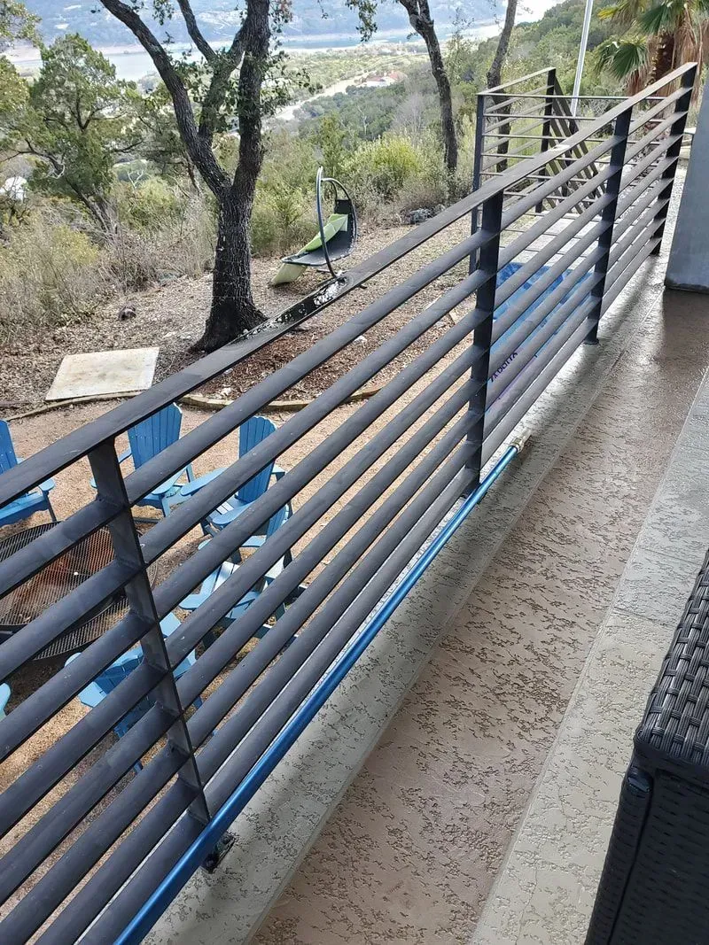 A balcony with a fence and chairs on it.