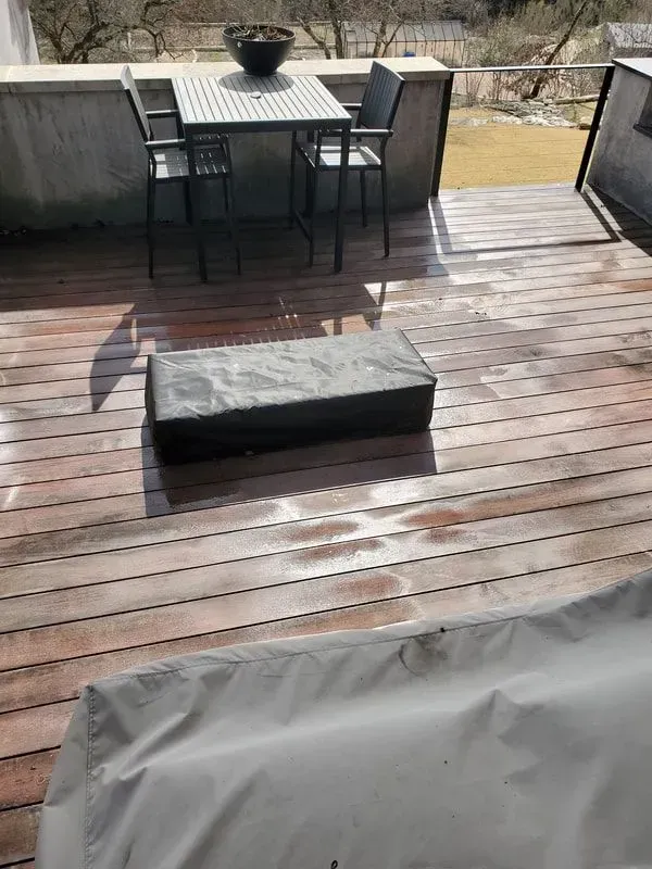 A wooden deck with a table and chairs on it.