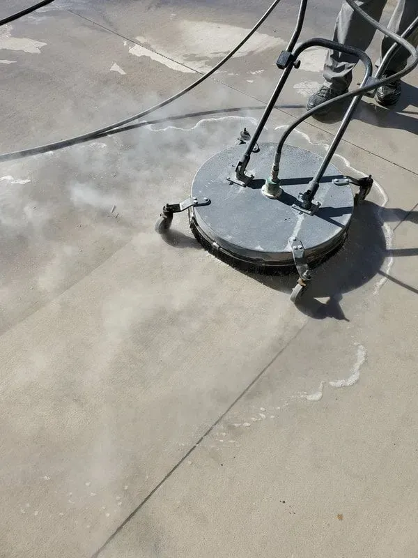 A person is using a machine to clean a concrete floor.