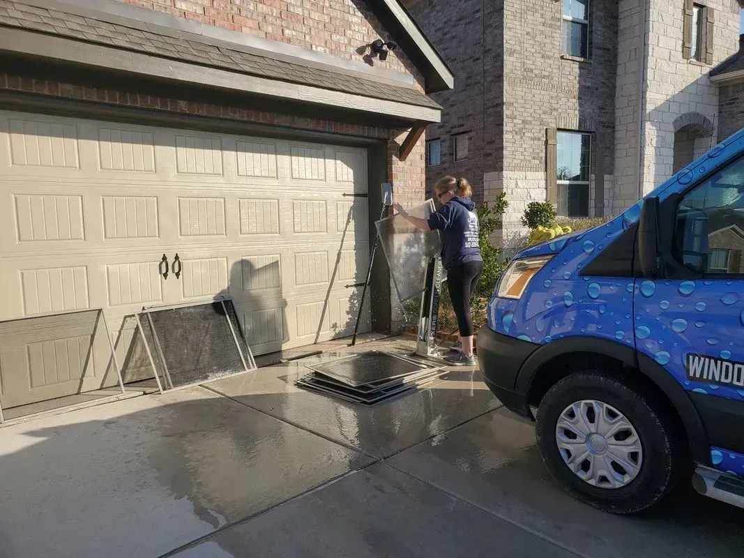 A blue van is parked in front of a garage door.