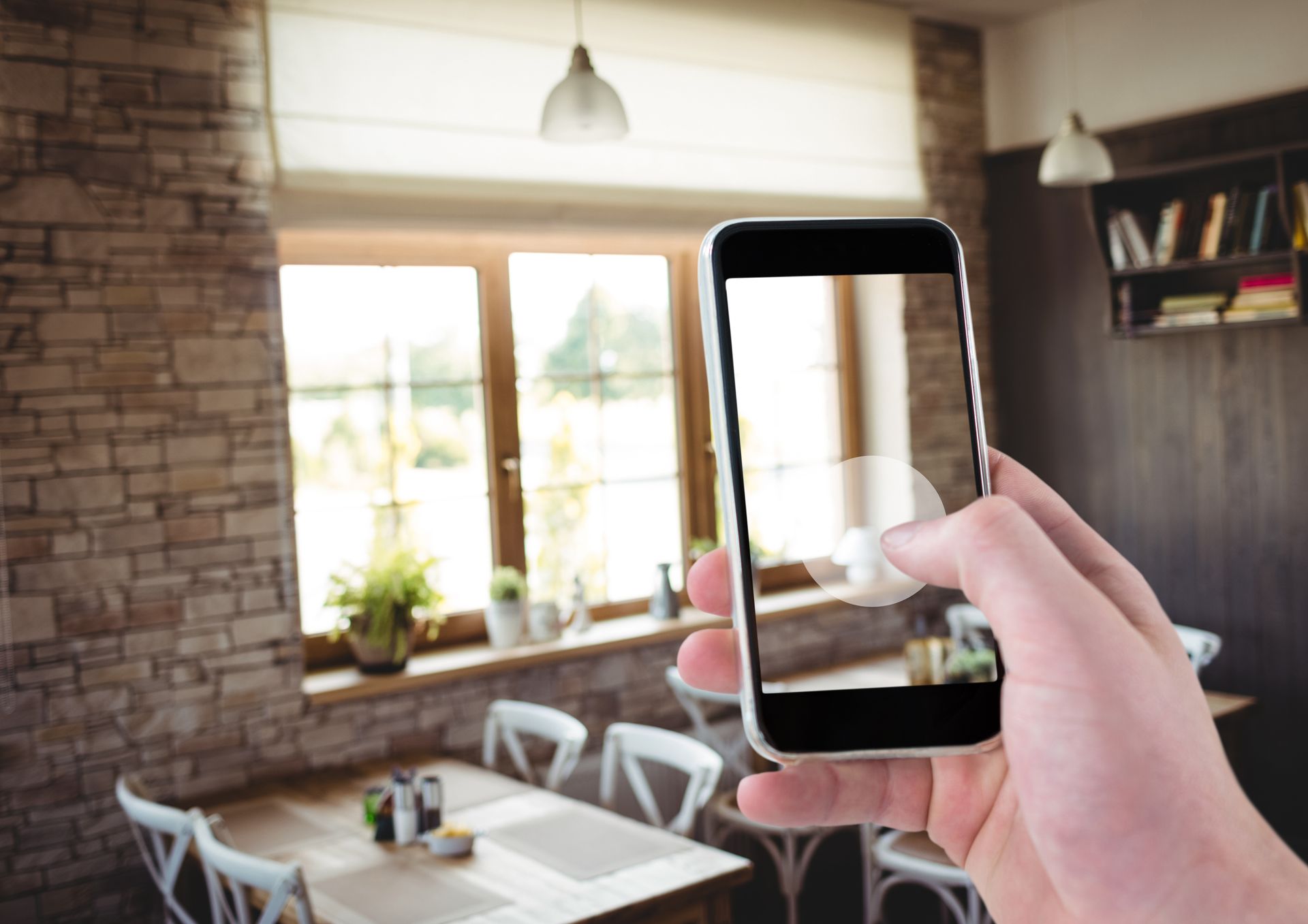 A person is taking a picture of a restaurant with a cell phone.