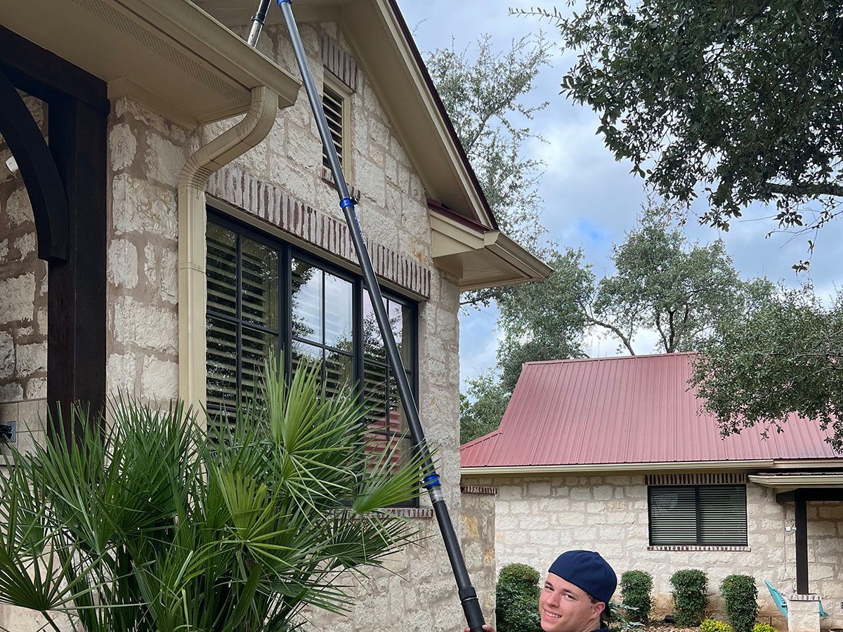 Cleaning high residential gutters with a vacuum system for safety 