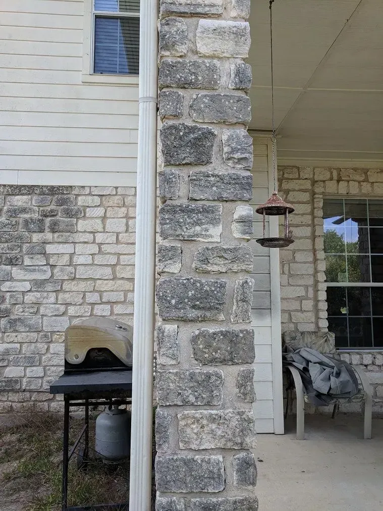 A brick building with a bird feeder on the side of it