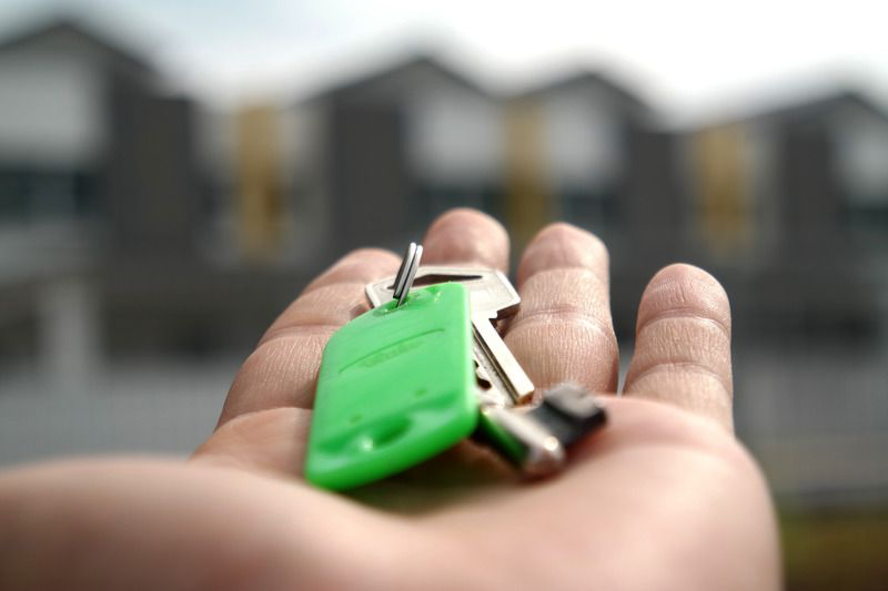 Close up of a person holding keys in the palm of their hand.