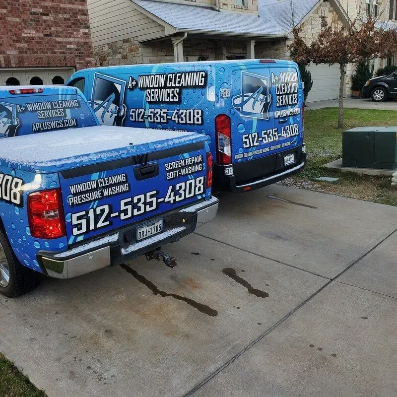 Two trucks are parked next to each other and one has the number 512-535-4408 on the back