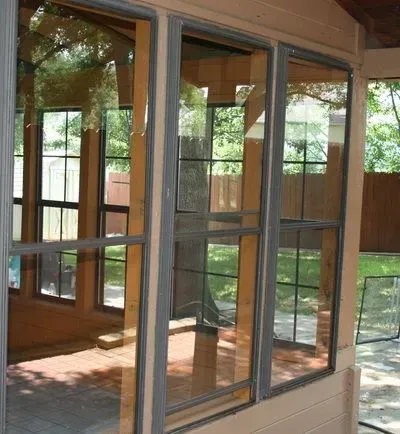 A room with lots of windows and a reflection of trees