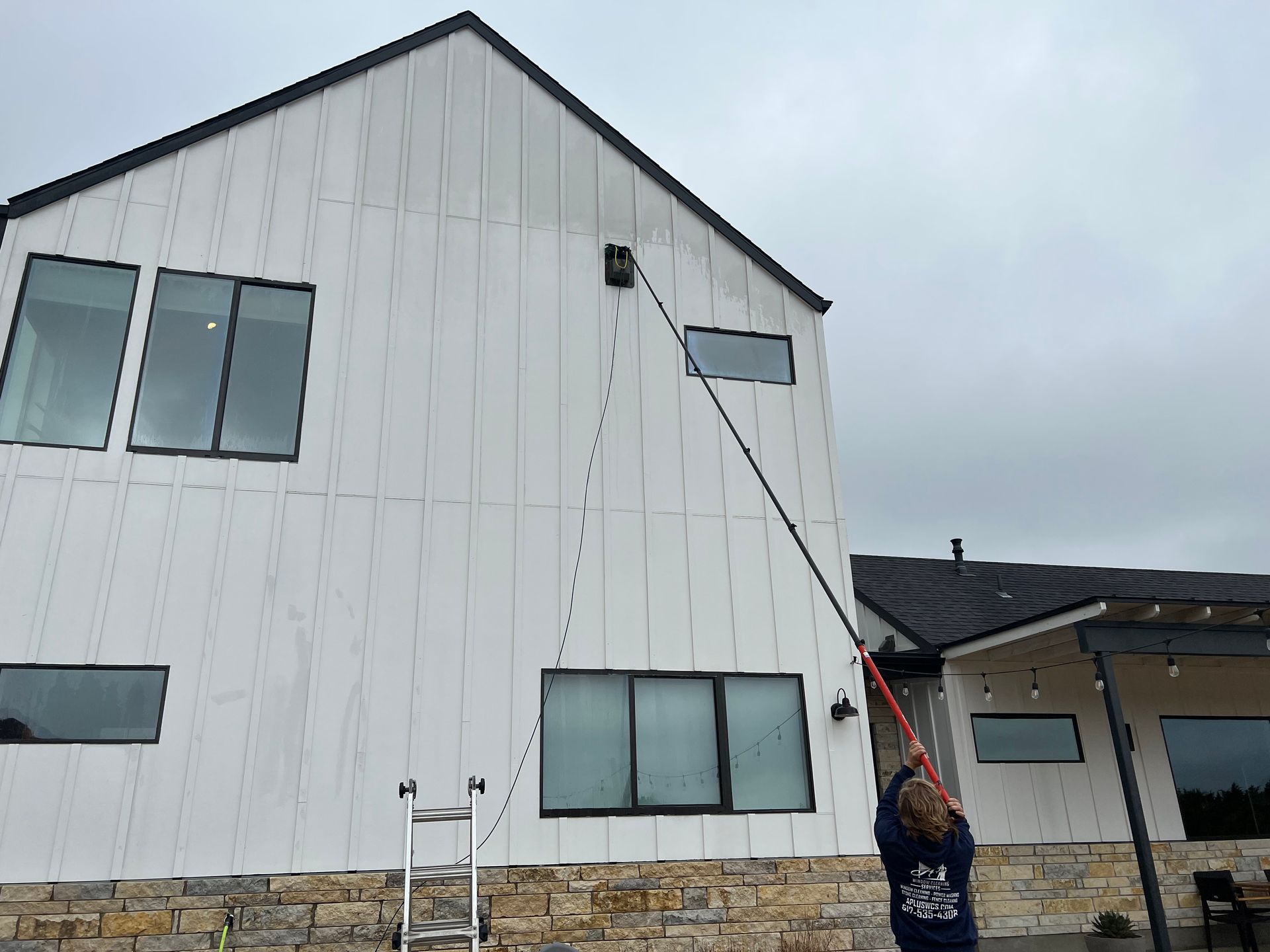 The dirty siding of a house being cleaned.