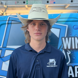 A young man wearing a cowboy hat and a blue shirt