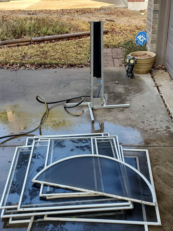 A bunch of screens are stacked on top of each other on the ground.