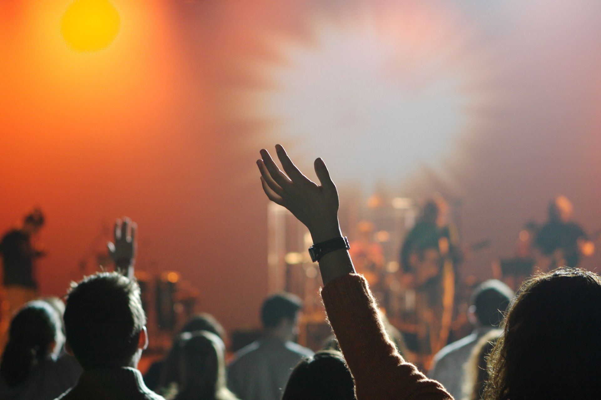 a crowd of people are raising their hands in the air at a concert