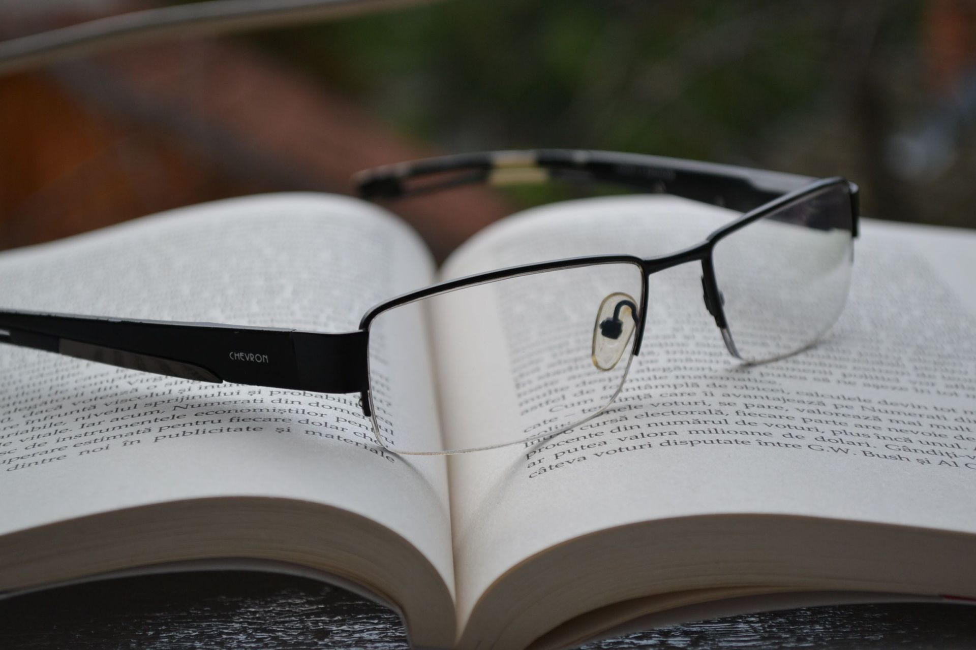 a pair of glasses laying on top of an open book