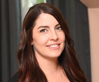 A woman with long brown hair is smiling for the camera.